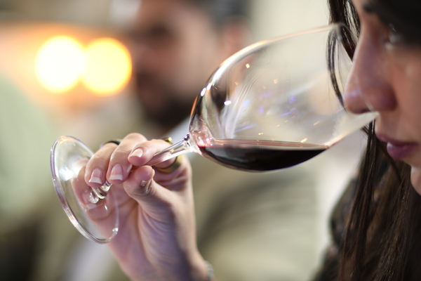 Mujer catando una copa de vino tinto 