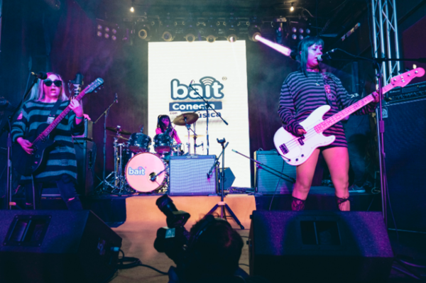 Mujeres jóvenes, pertenecientes a una banda de rock, tocando 