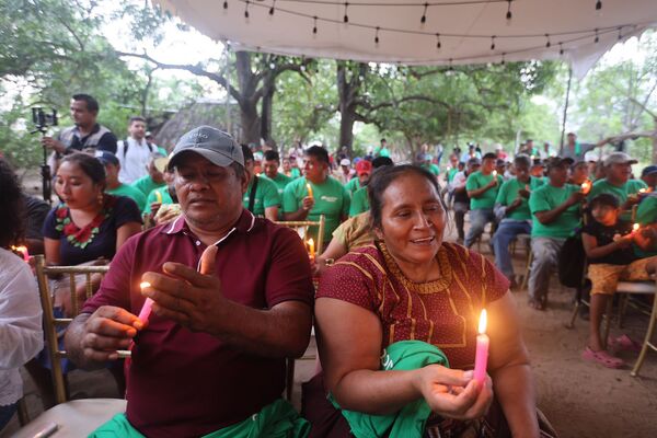 Beneficiarios de Luces de esperanza sosteniendo velas encendidas