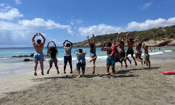 Jóvenes saltando juntos en una playa 