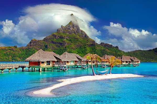 Paise de la isla de Bora Bora con una montaña de fondo, cielo azul y palmeras