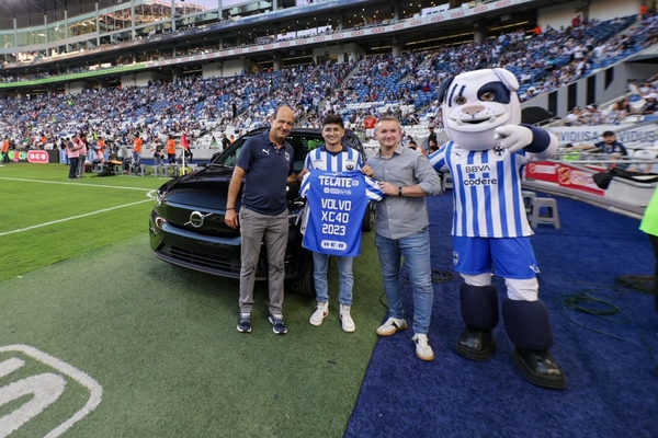 Directivo, aficionados y mascota del Club Monterrey frente un Volvo