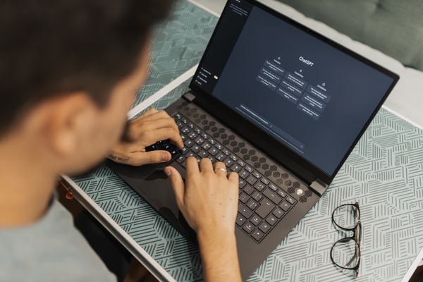 Joven con la pantalla de inicio de ChatGPT en su laptop