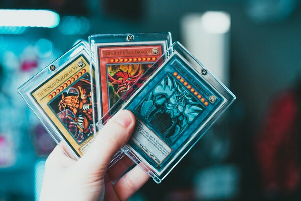 Mano masculina sosteniendo cartas de Yugioh