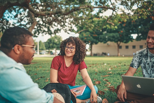 Estudiantes conversando sentados en el jardín