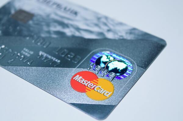 Foto de una tarjeta mastercard plateada sobre una superficie blanca