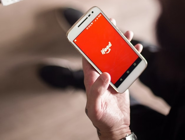 La mano de un hombre sosteniendo un smartphone con iFood abierta